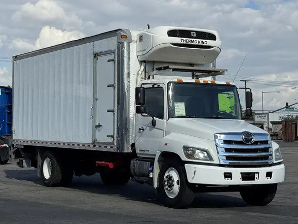 Hino 338 with a reefer body parked in a parking lot