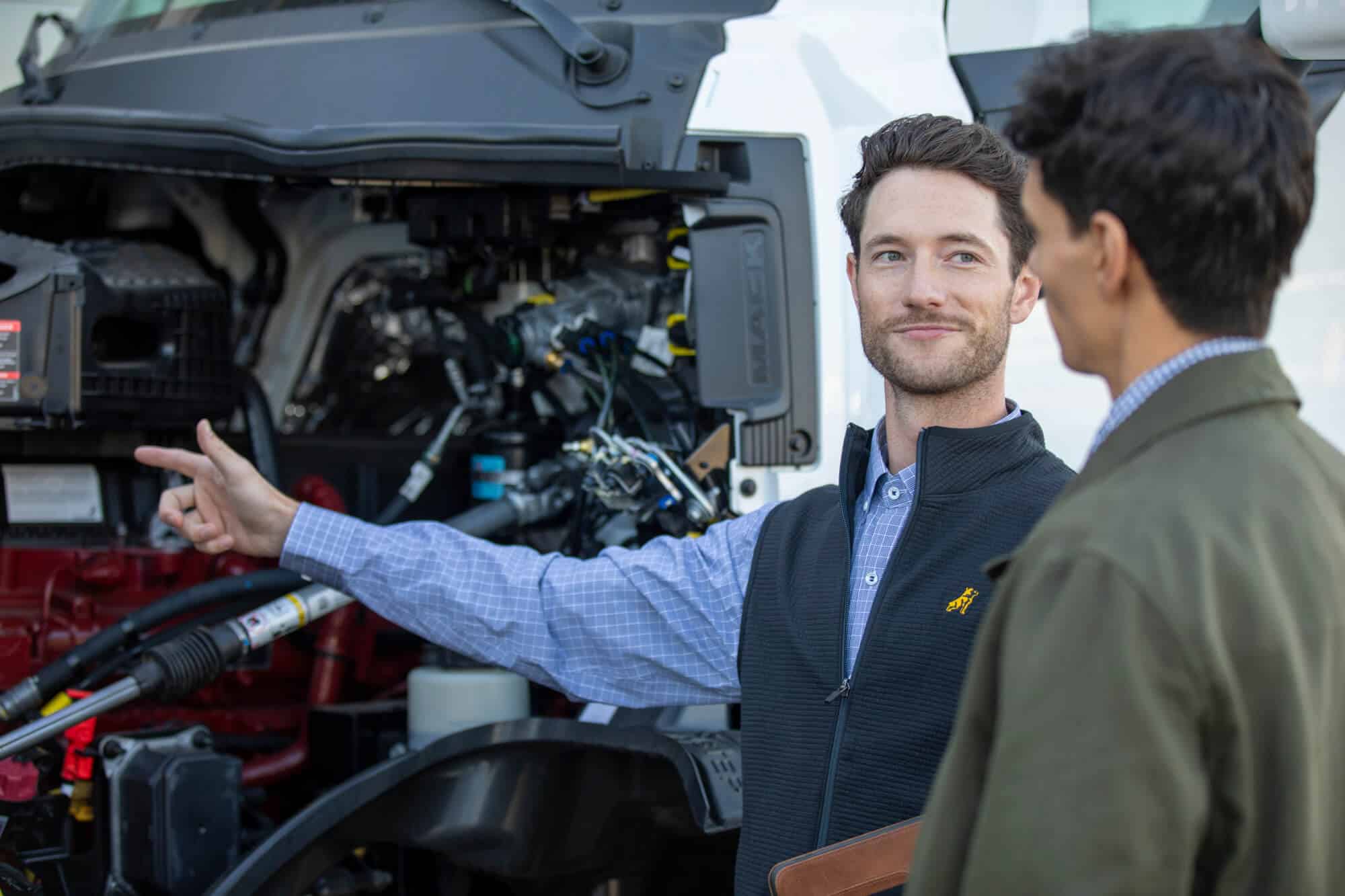 Sales Person Pointing to a Mack Engine with Customer