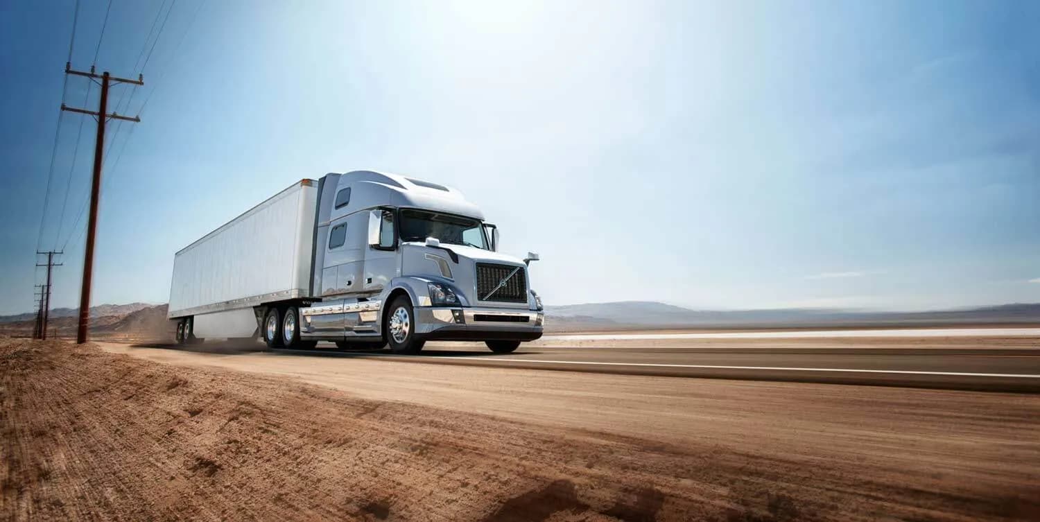 Light blue Volvo VNL truck on a remote desert road