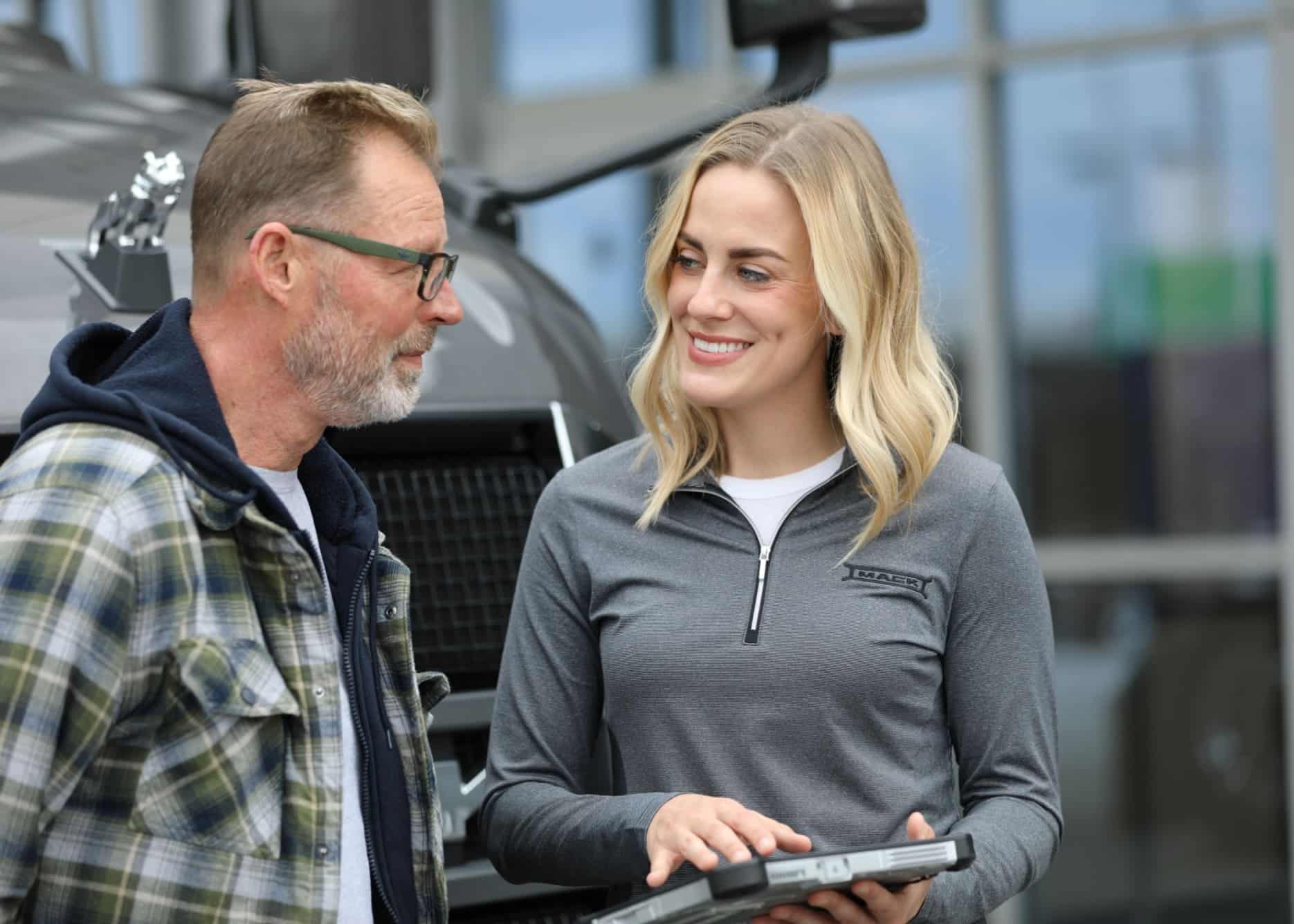 Insurance agent talking with a customer in front of a truck.